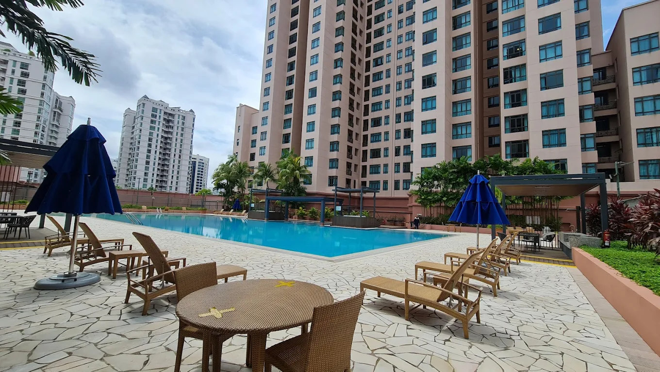 Apartment towers with a pool and lounge chairs in the courtyard